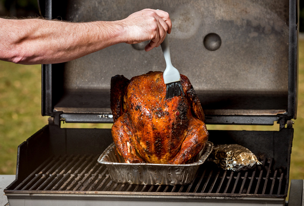 Basting a Turkey on a BBQ with a brush