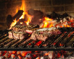 Brazilian BBQ Beef on a hot grill with a fire in the background