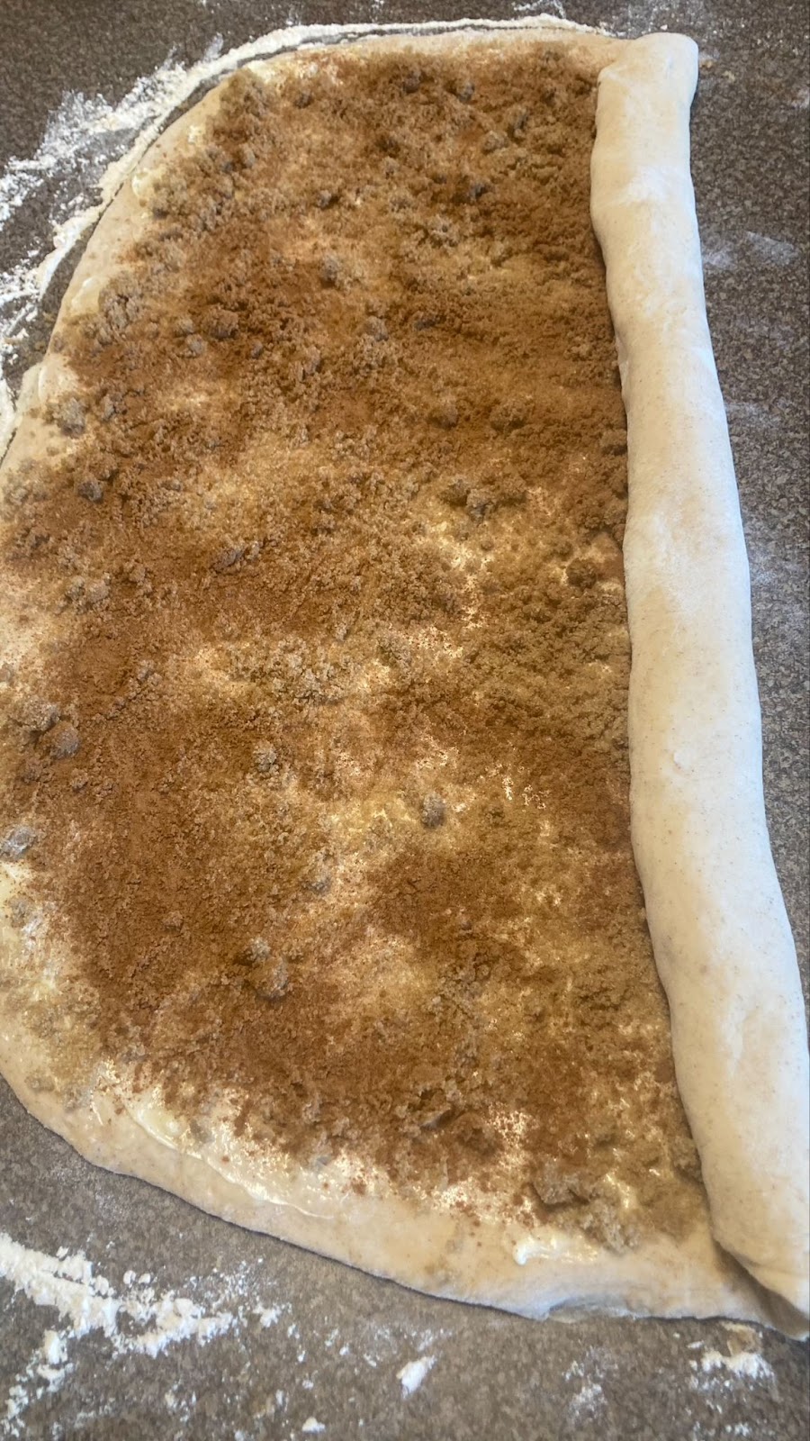 Cinnamon roll dough with cinnamon and sugar on it - partially rolled to go on the grill