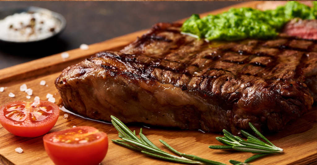 Grilled carne Asada on a cutting board with sliced tomato for the Day of the Dead recipe Grillers Gold Blog