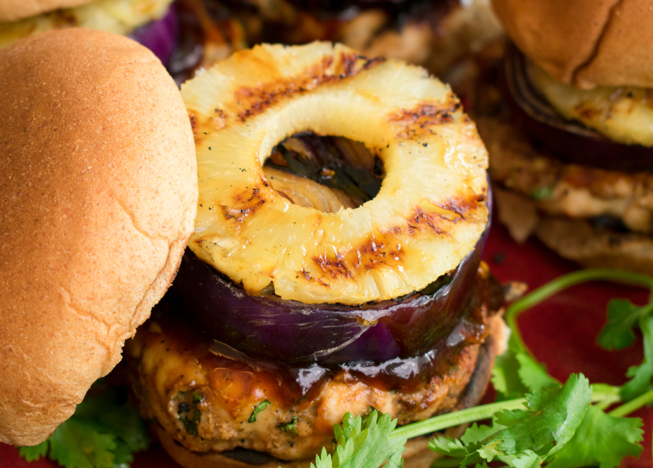 grilled pineapple on top of a grilled onion and plant based burger