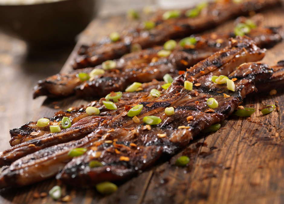 Korean style ribs on a wooden board with green onions for garnish