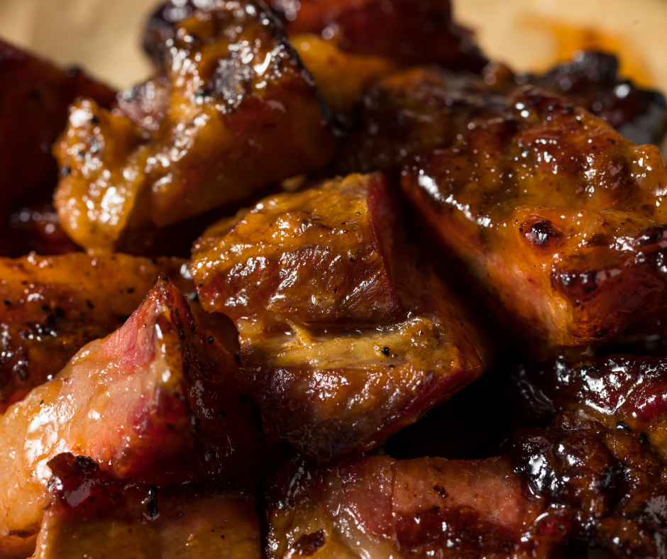 A close up of burnt ends in a sticky sauce
