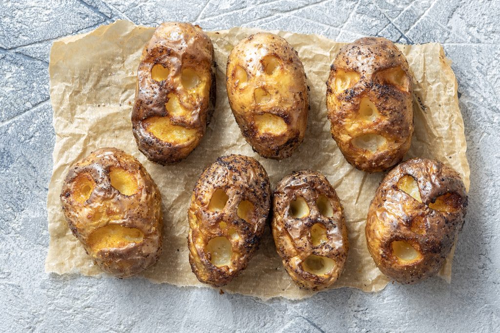 Shrunken Head Smoked Potatoes on a grey tile background and parchment paper
